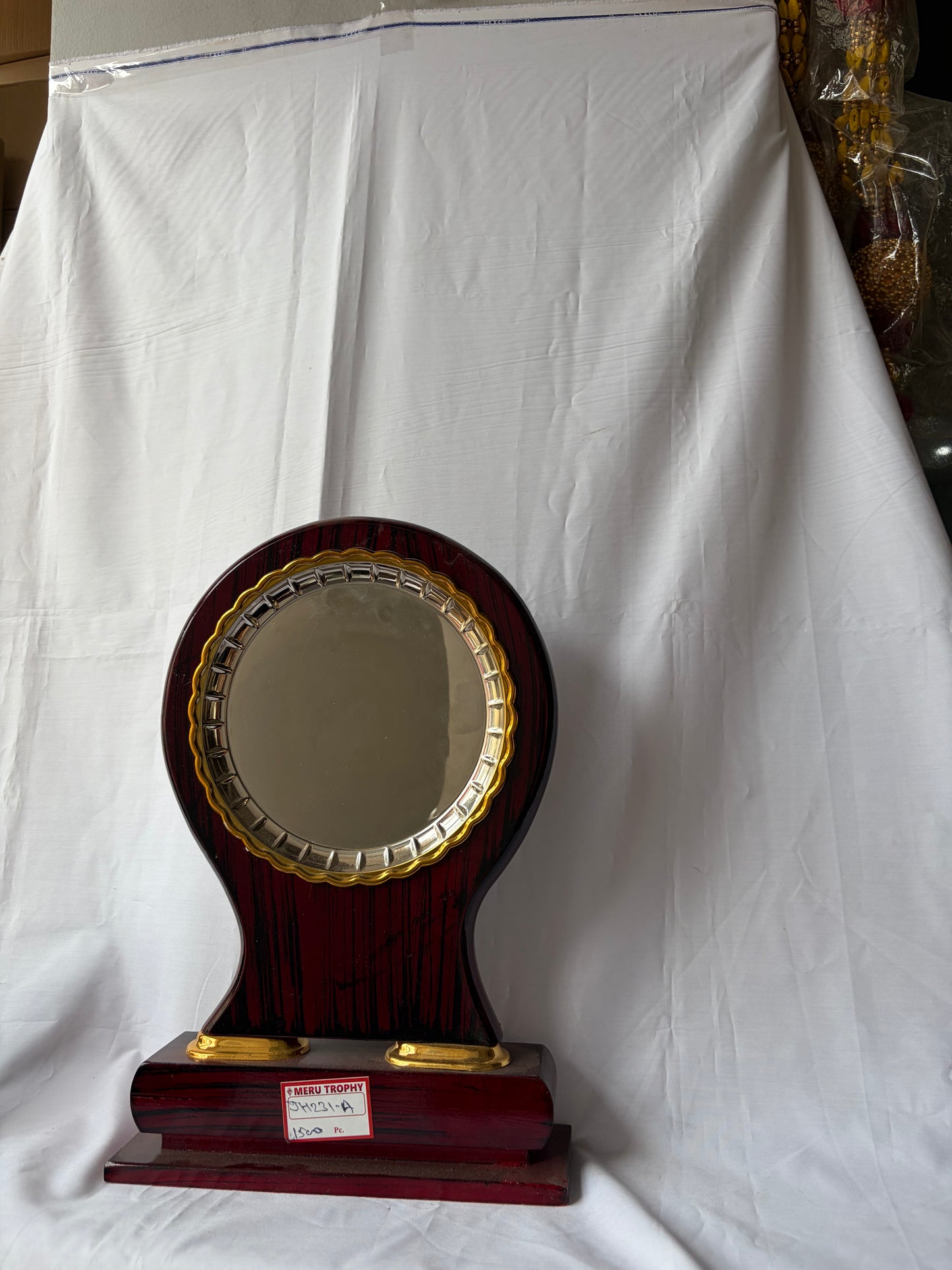 JH 231 A dark wood circular decorative plaques featuring a gold metal trim and a polished pedestal base for formal awards.