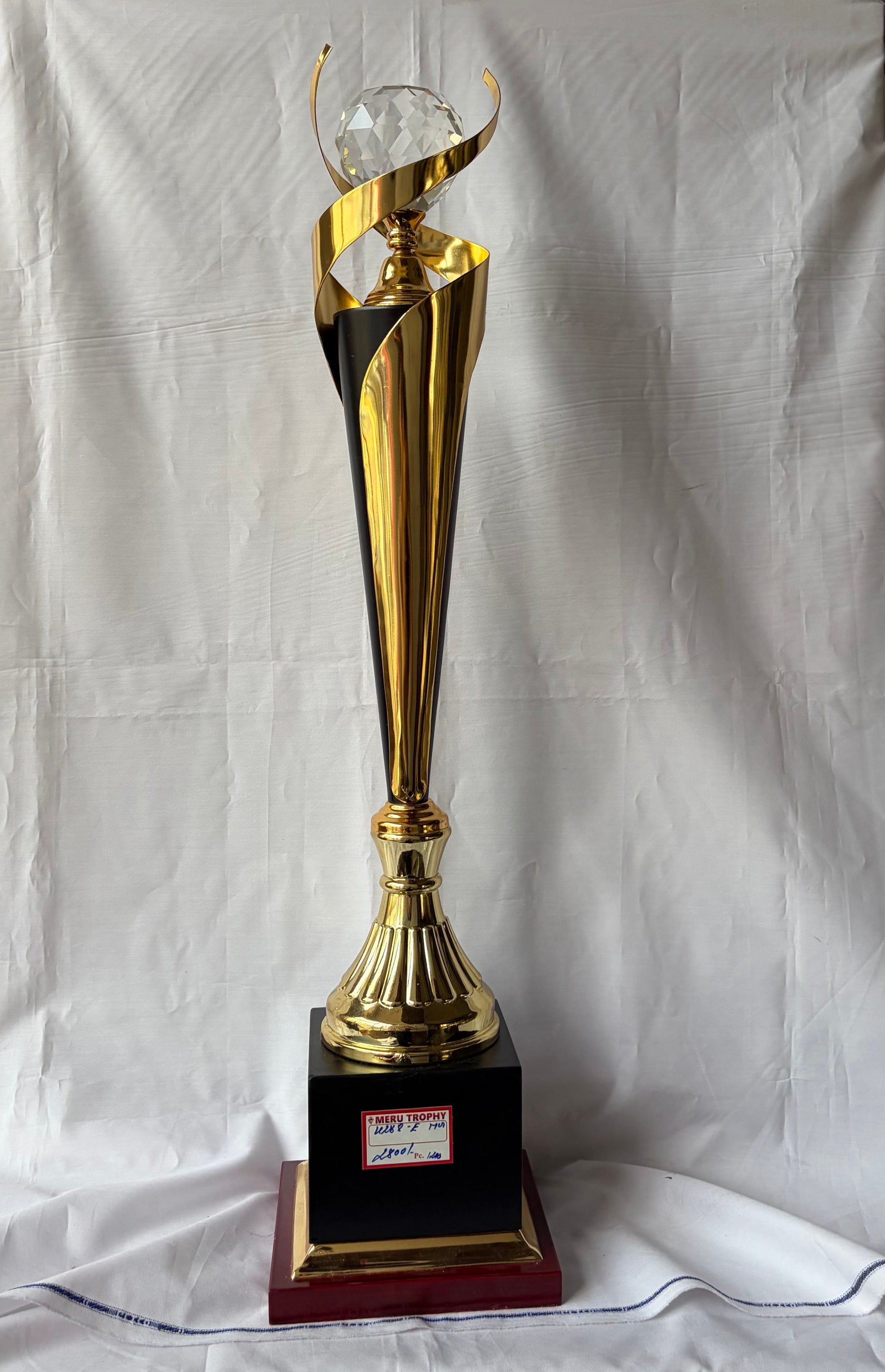Elegant 4288 E gold and black trophy with a large clear crystal orb topper and swirling gold ribbon for awards.